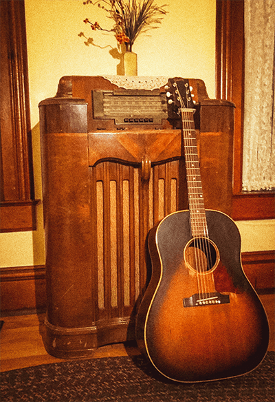Guitar leaning against a vintage radio